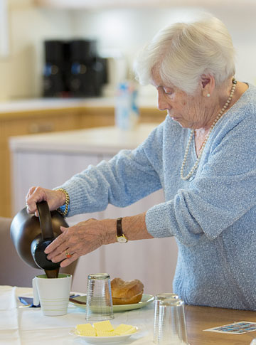 Bewohnerin schenkt sich einen Kaffee zum Frühstück ein